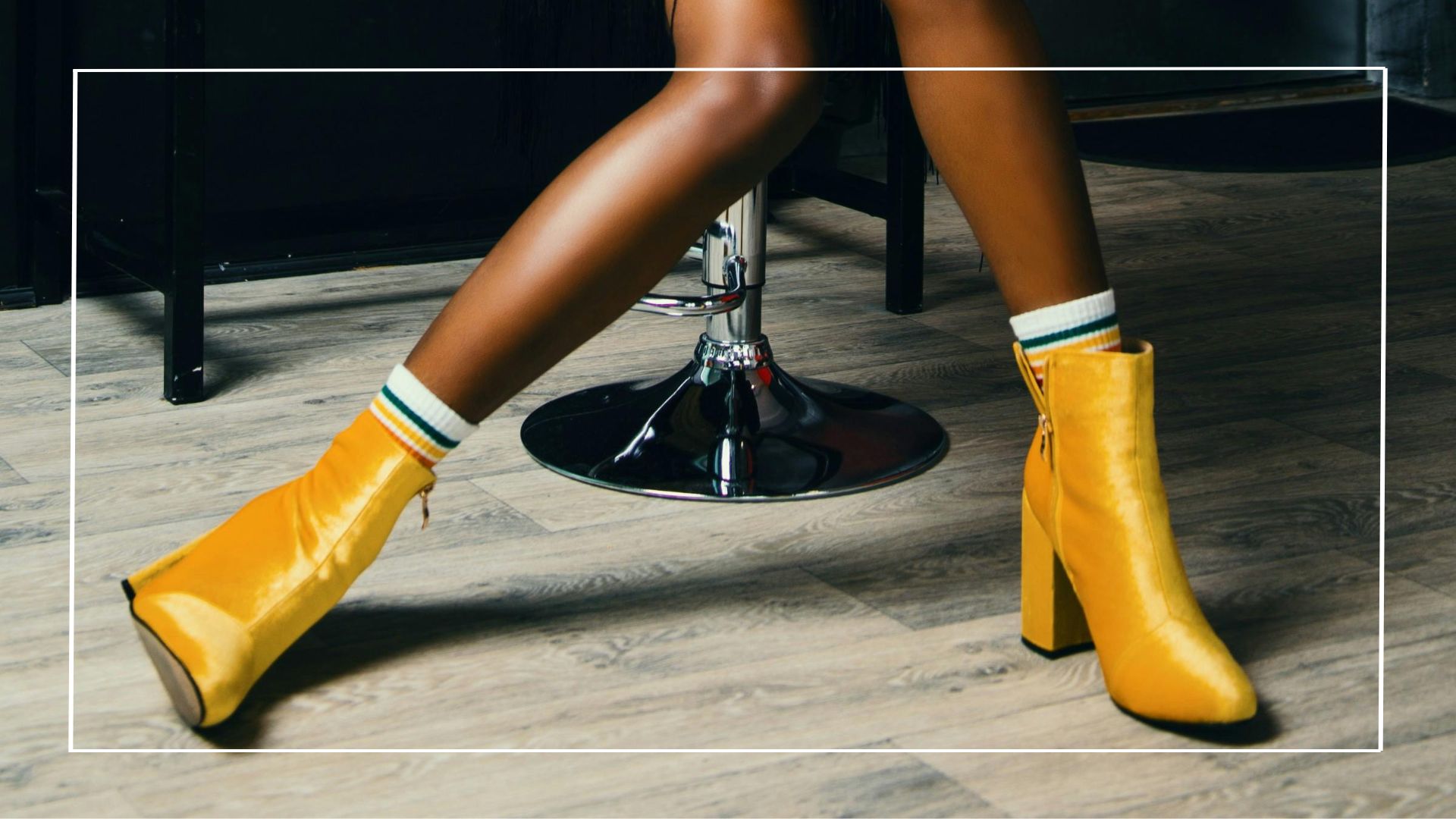 Pernas de uma mulher negra mostrando como lacear uma bota amarela