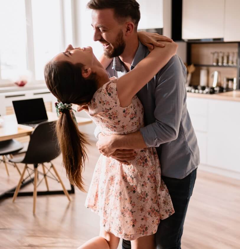 Casal dançando na cozinha.