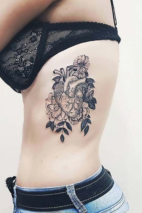 coração realista com flores tatuado na costela