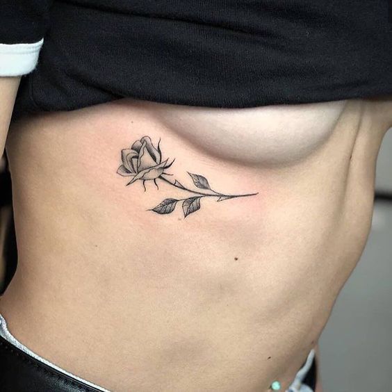 rosa delicada tatuada na costela 