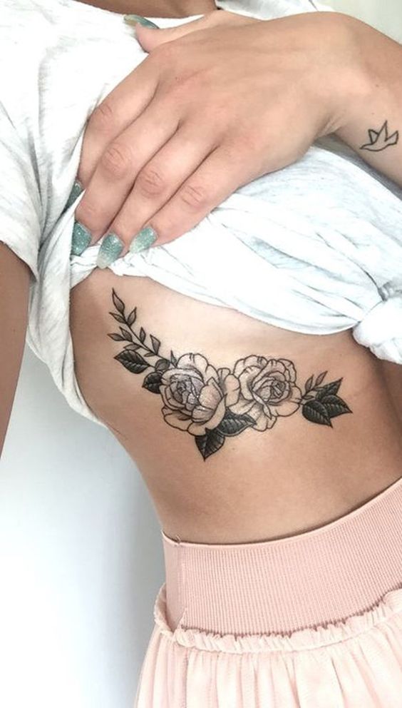 tatuagem de flor com folhas pintadas na costela 