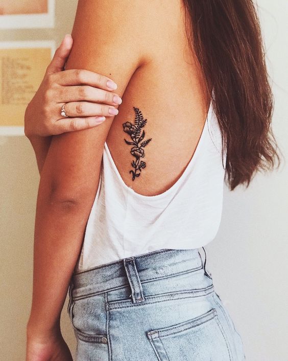 flor com linhas grossas tatuada na costela