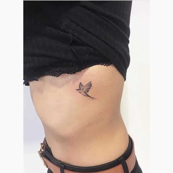 tatuagem de passarinho voando na costela 