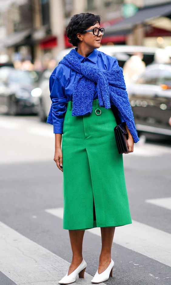 modelo veste blusa azul com saia verde bandeira suave e calçado branco