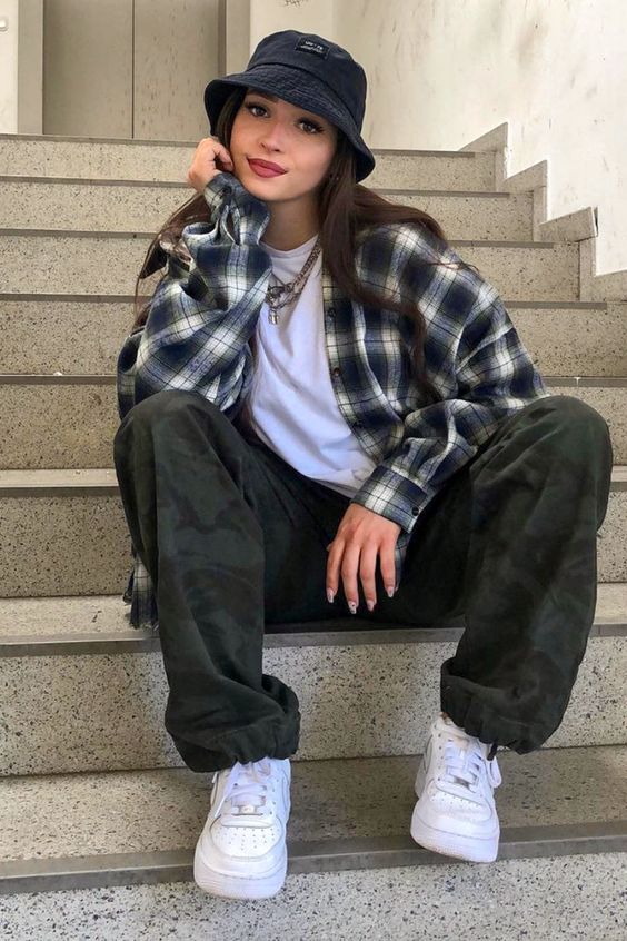 menina veste camisa xadrez e calça solta - caracteristico do estilo grunge