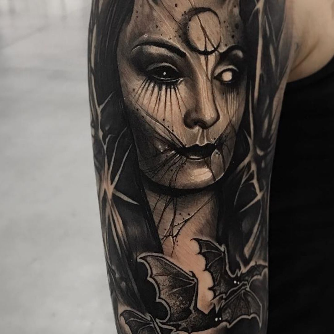 Tatuagem feminina de uma bruxa e morcegos 
