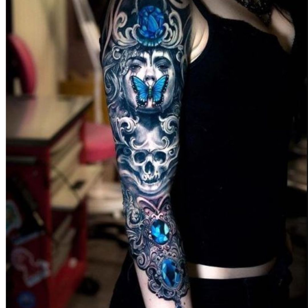 Braço de um mulher todo tatuado com desenho de rotos e borboletas coloridas