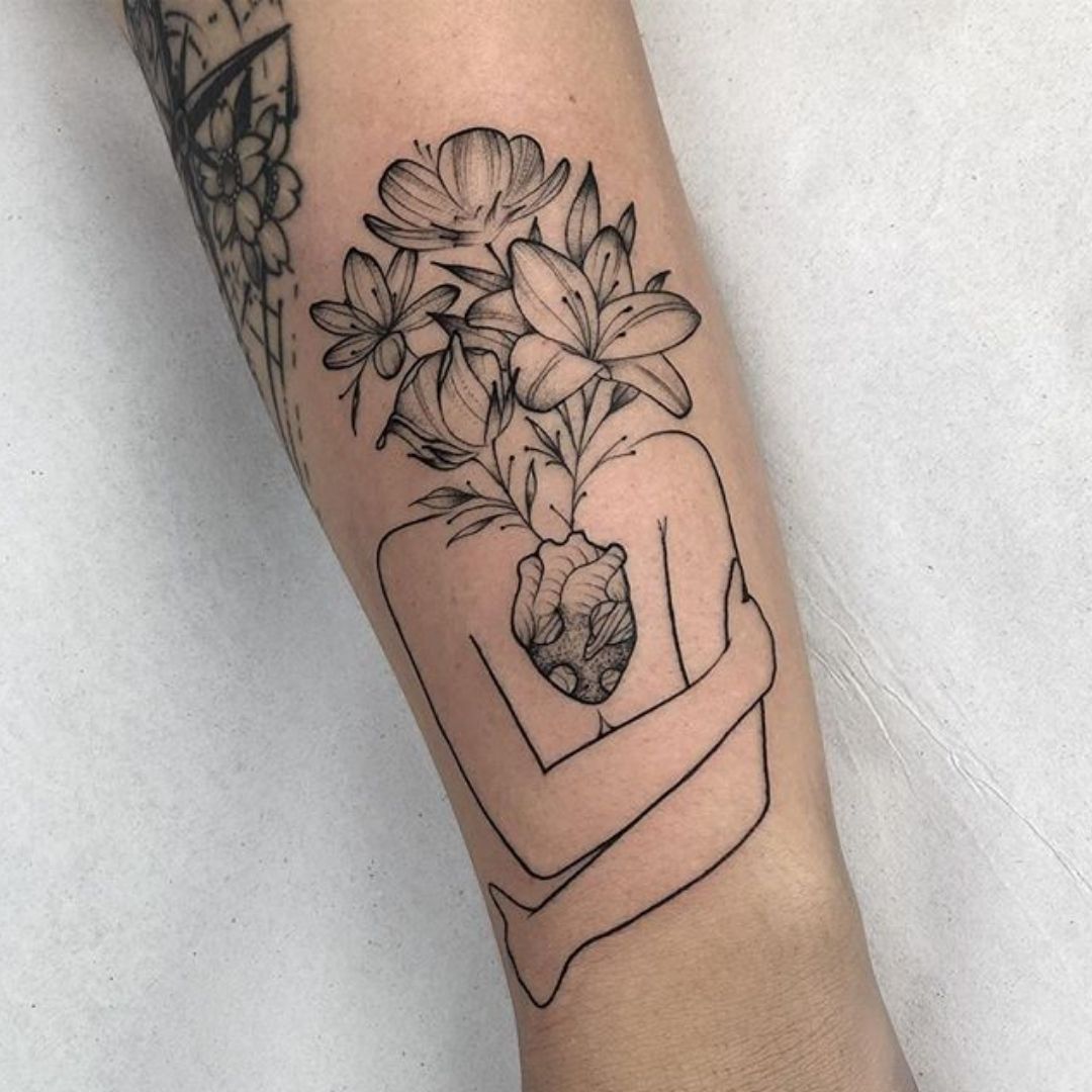 Tatuagem de um abraço com flores saindo do coração