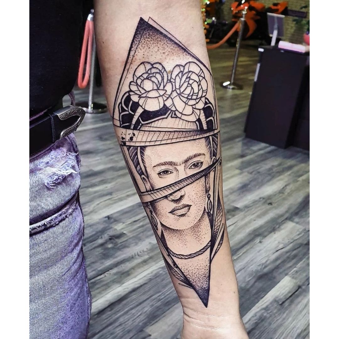 Tatuagem no braço com um rosto dentro de triangulo  desenho assimétrico 