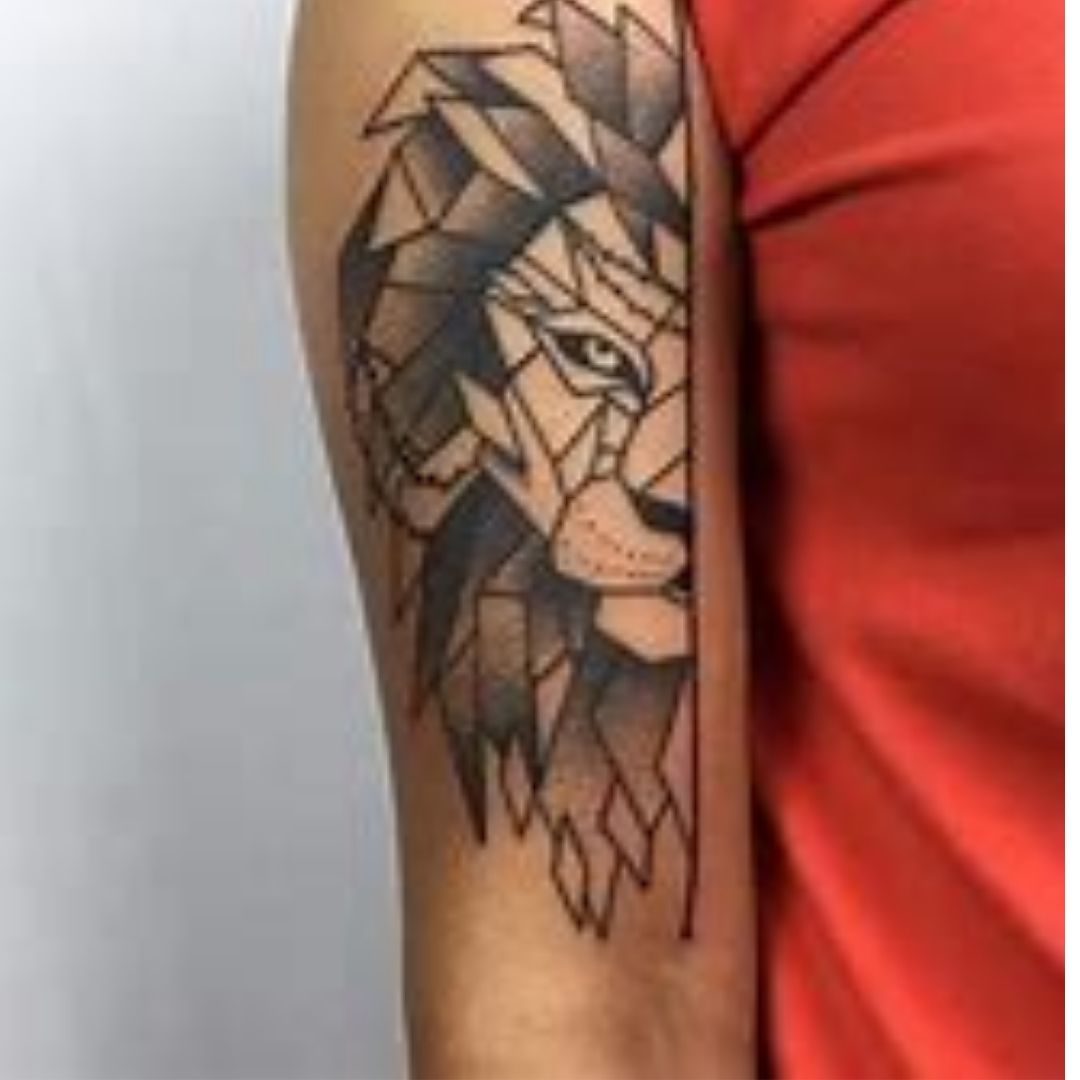 Tatuagem no braço com a metade um de um leão com desenho assimétrico 