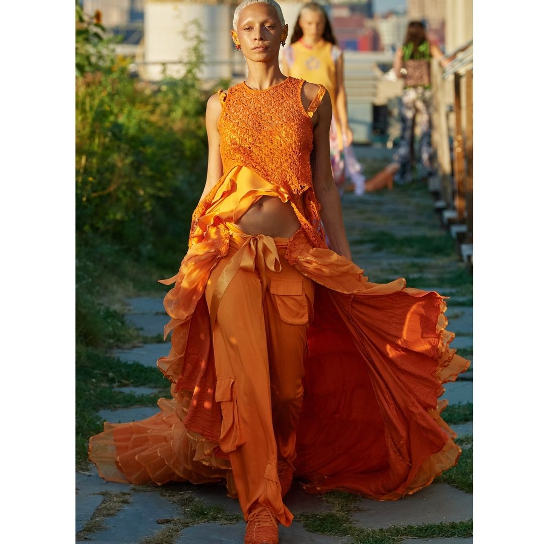 Mulher andando na rua  com uma roupar cor laranja Cores do inverno