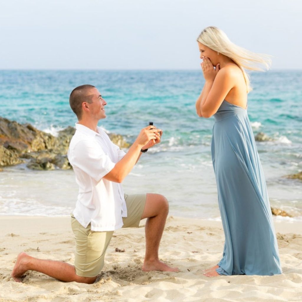Mulher sendo pedida em casamento na praia
