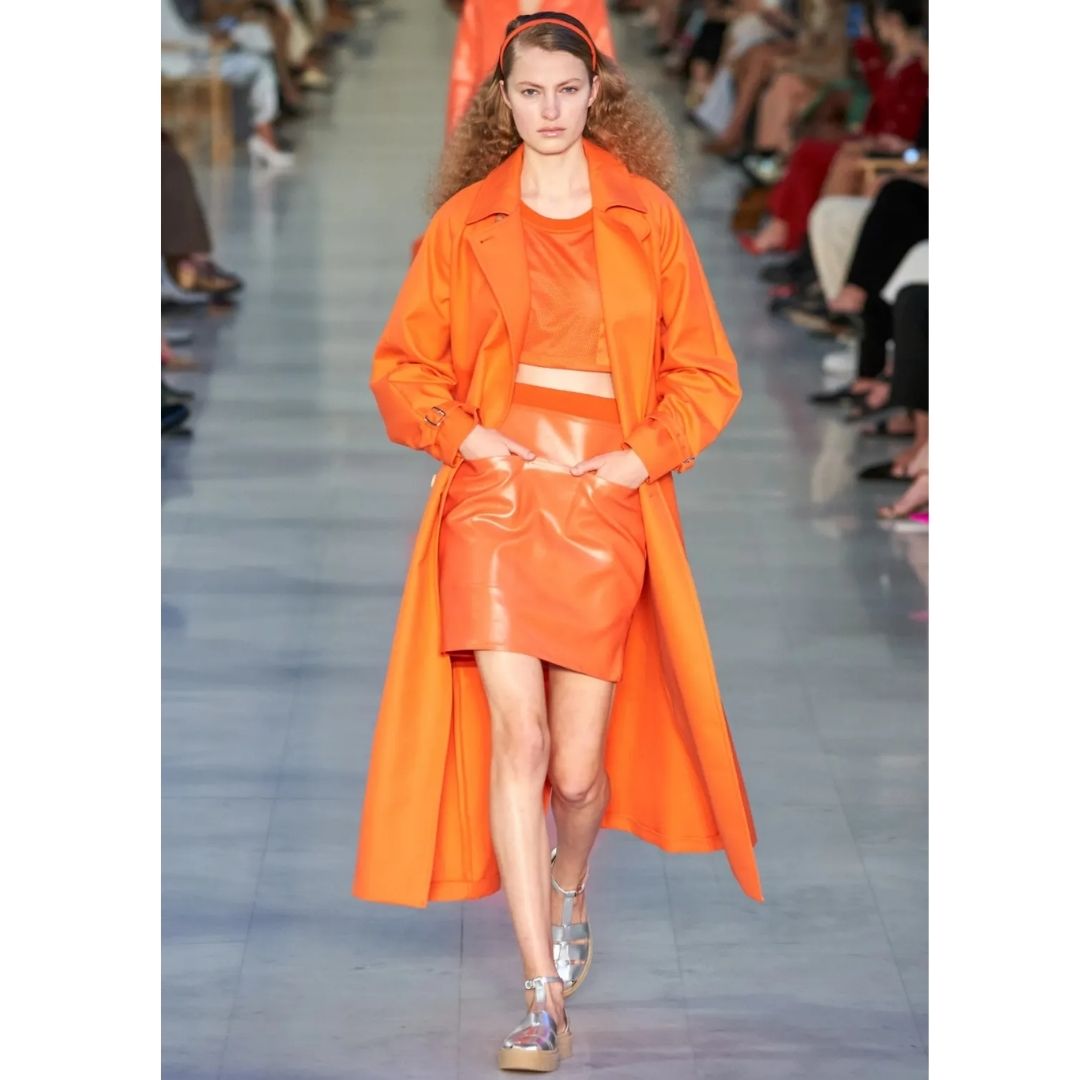 Modelo desfilando  com uma roupar cor laranja Cores do inverno