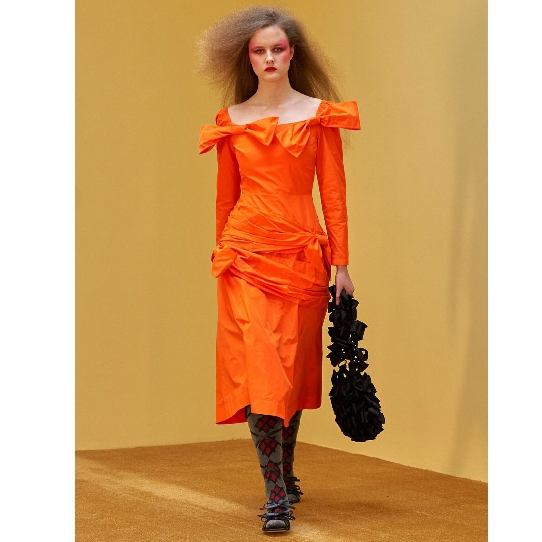 Modelo desfilando  com uma roupar cor laranja Cores do inverno