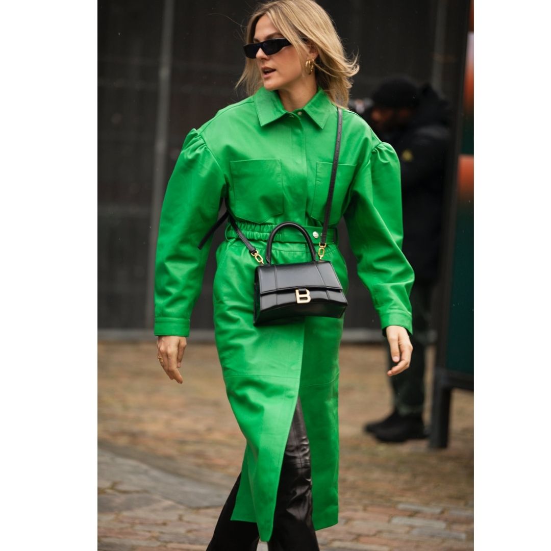 Mulher andando na rua usando um sobre tudo verde 