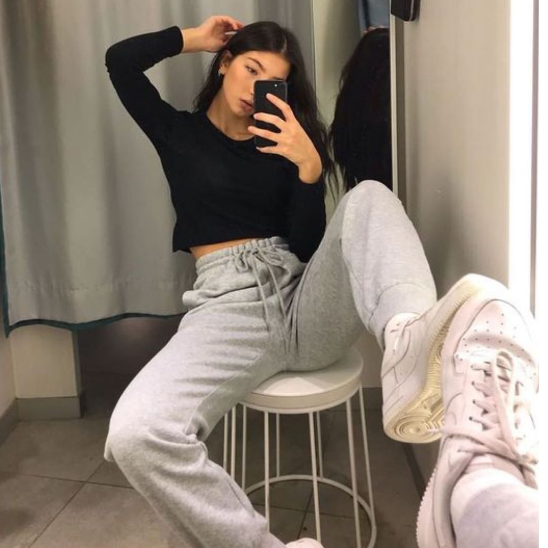 Mulher tirando fotos sozinha de frente ao espelho usando dicas de Poses Para Fotos Perfeitas