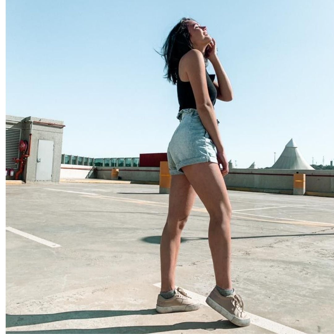 Mulher pousando para fotos na rua ,usando dicas de pose para fotos sozinhas