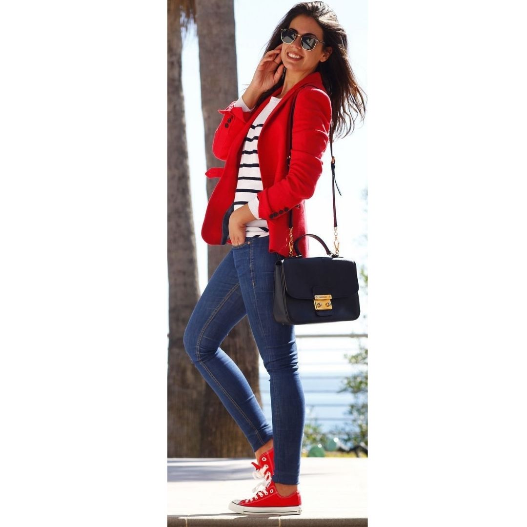 Mulher na rua com look casual composto por blasé e tênis vermelho 