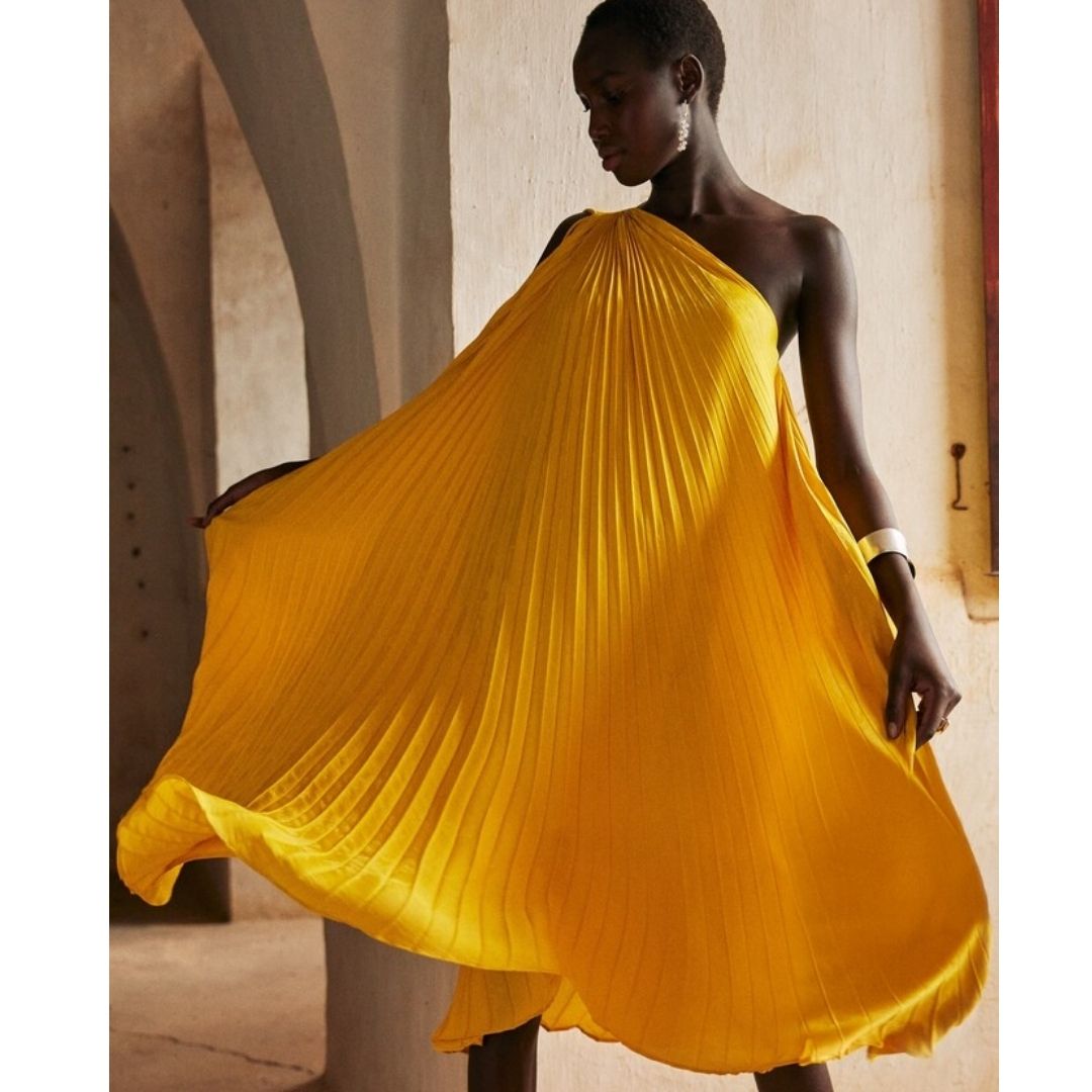 Modelo pousando para foto com um vestido amarelo na moda saia do básico
