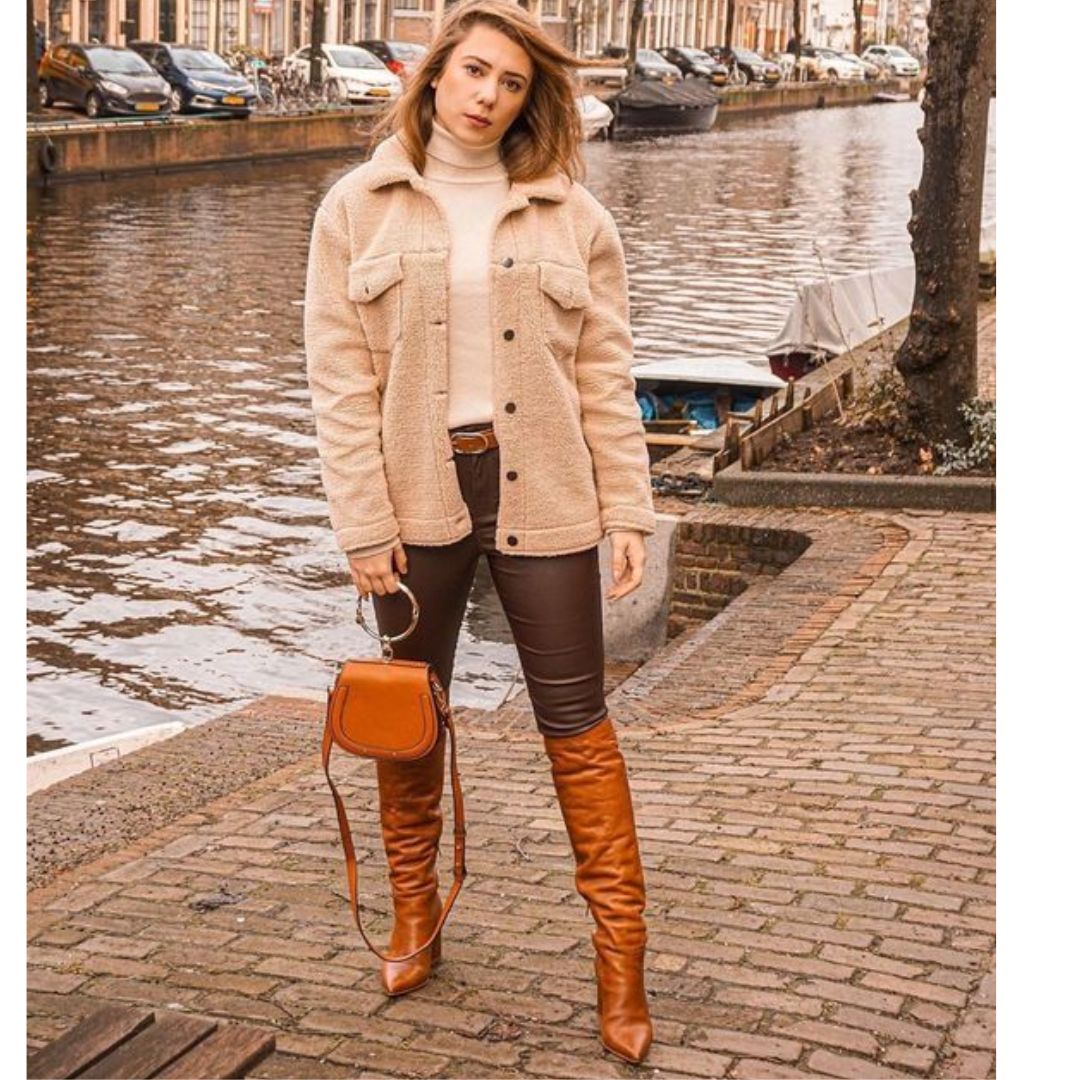 Mulher na rua posando para fotos usando look com botas caramelo 