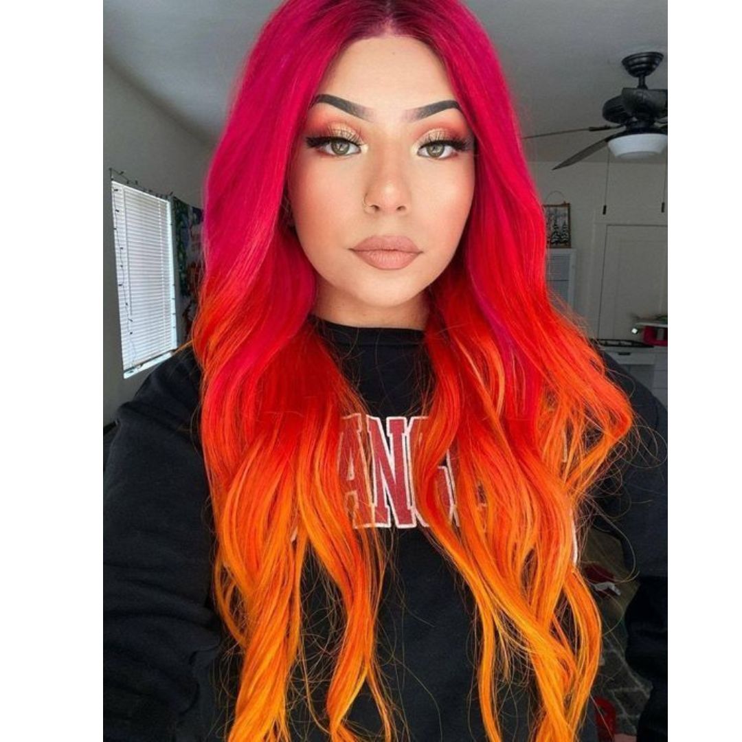 Foto de uma jovem com coloração de cabelos em degradê das cores rosa e laranja 