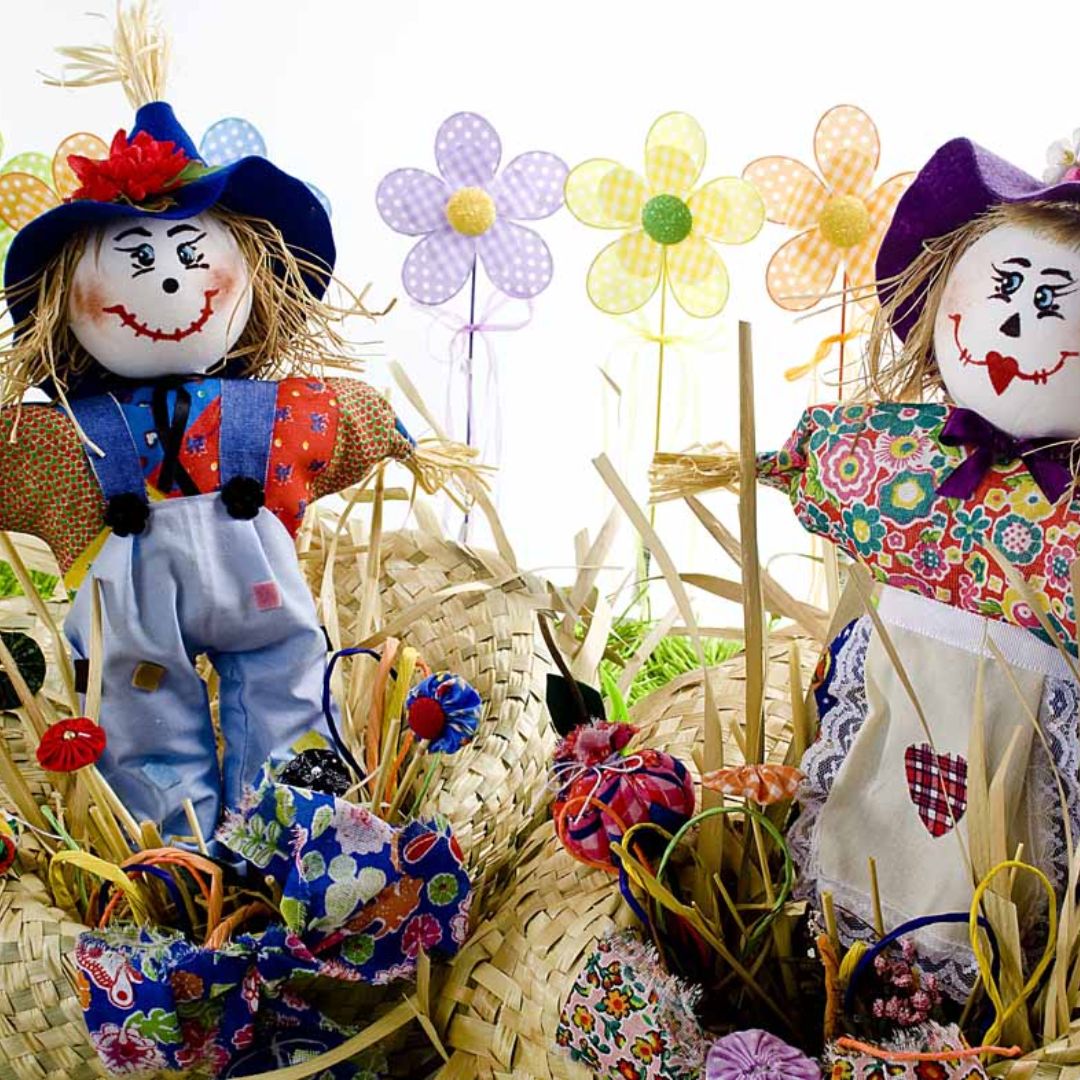 Mesa decorada com bonecos de palhas para festa juninas
