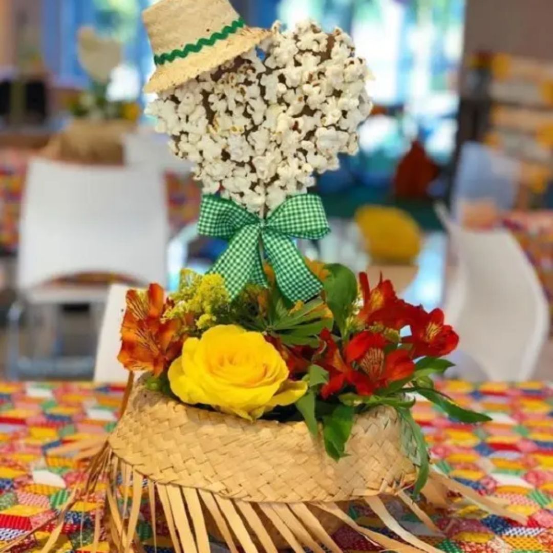 Coração de chocolate decorado com pipoca, dentro de um chapéu com flores