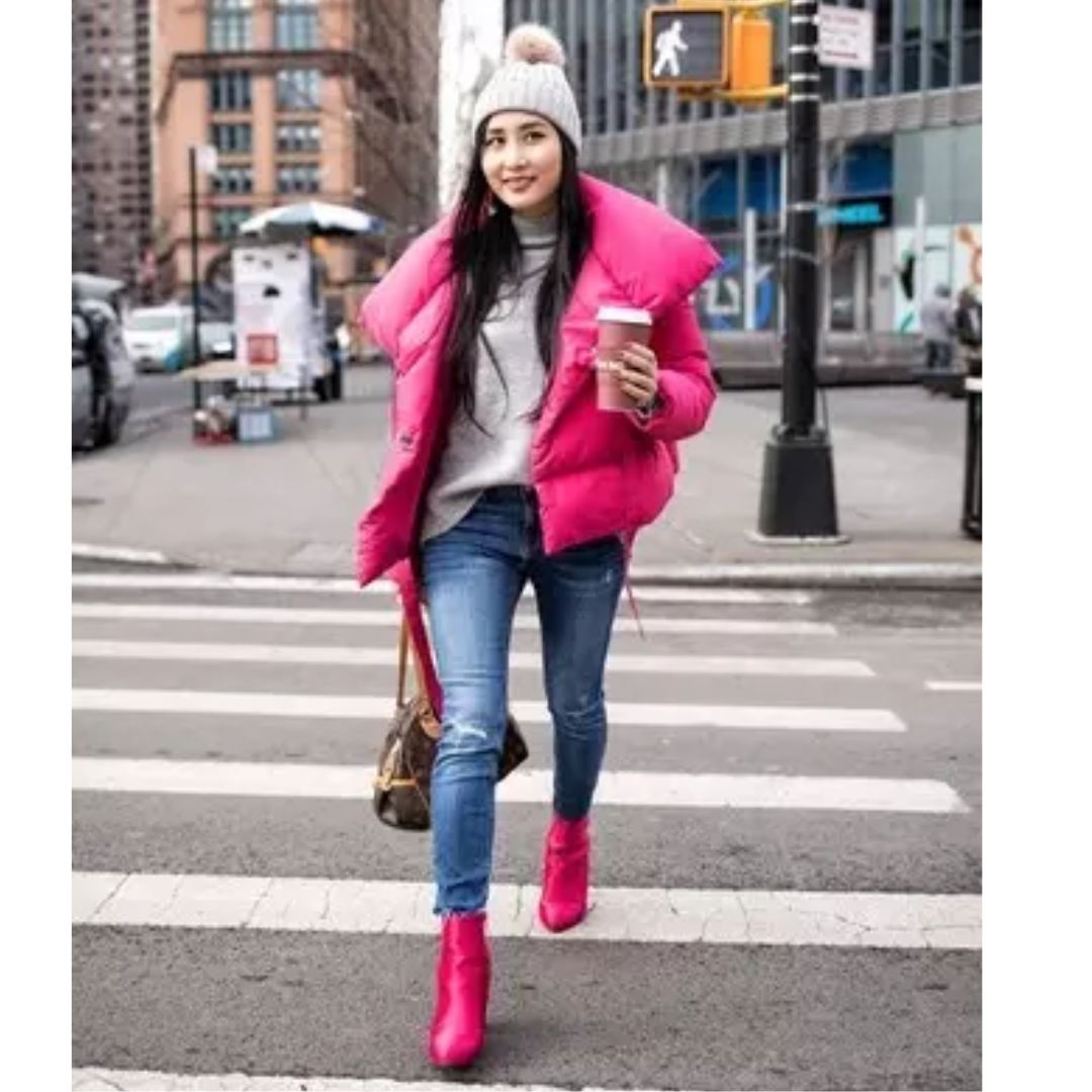 Modelo na rua usando jeans, touca, colete e botas rosa