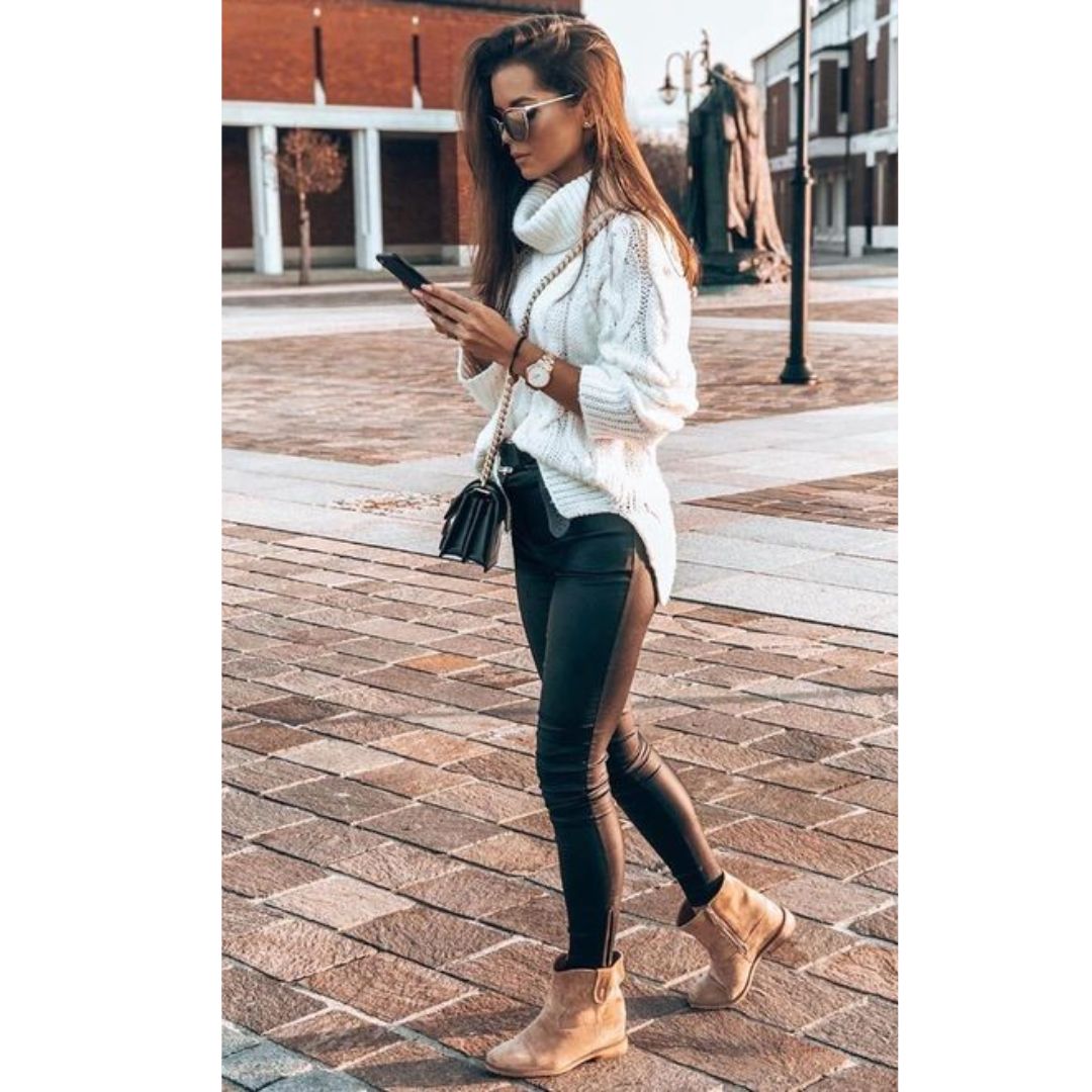 Look de frio composto por um suéter branco e calça preta