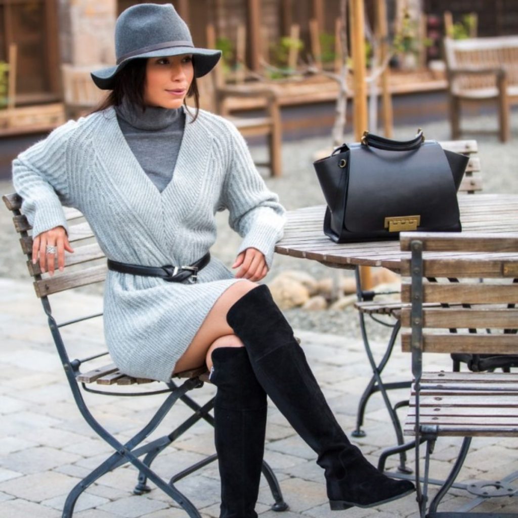 Mulher sentada em uma praça usando look de inverno