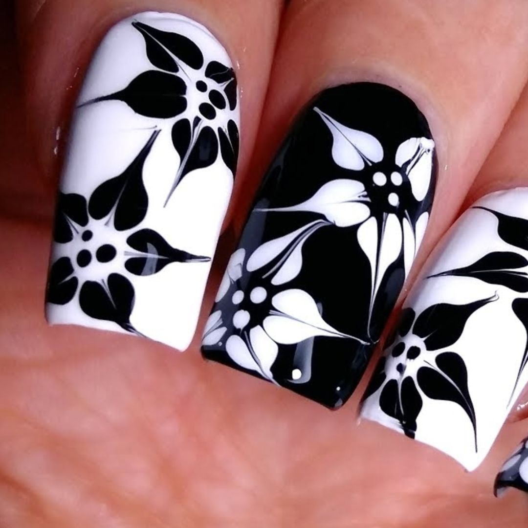 Unhas preta e branca com decoração de flores