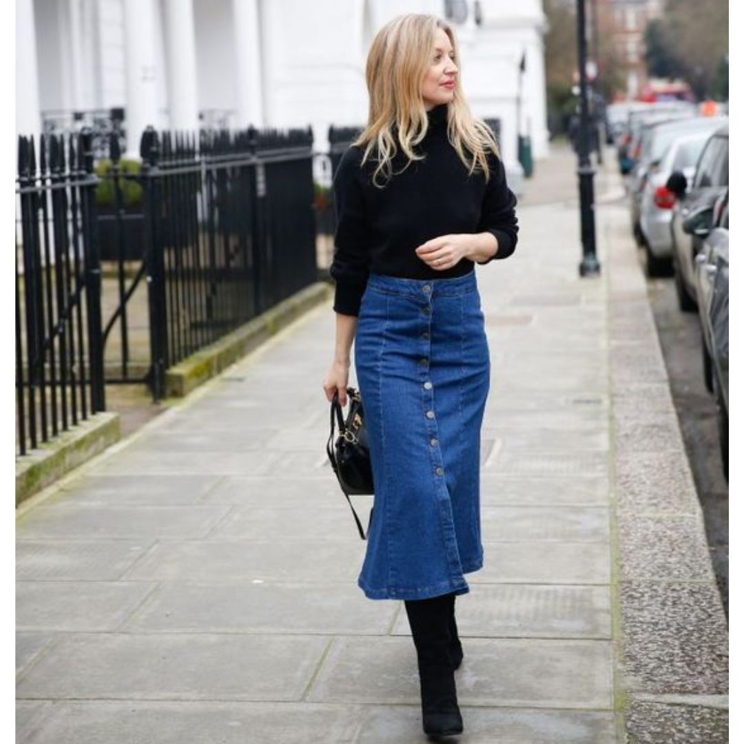 mulher loira usando look com saia jeans longa em um dia frio