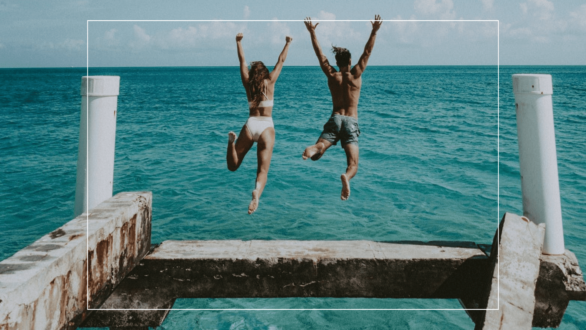 Duas pessoas pulando no mar