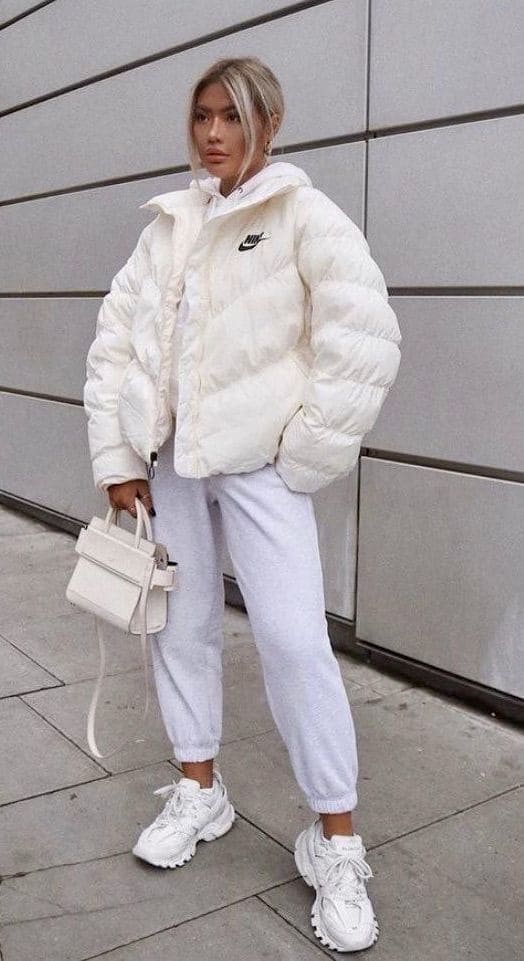 Look com bolsa branca, tênis branco, calça de moletom e jaqueta.