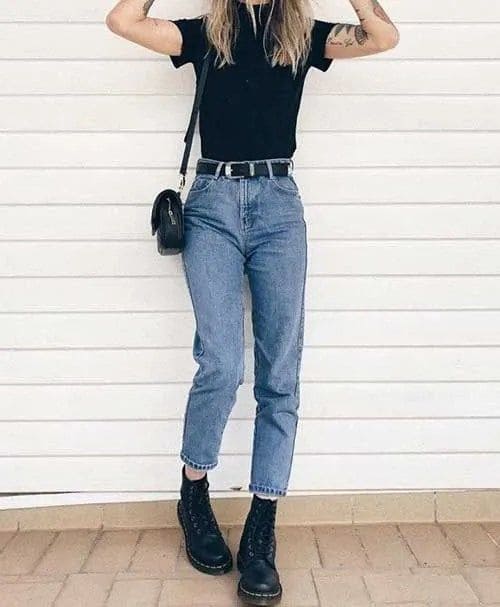 Look com calça mom jeans com cinto preto, coturno, bolsa e camiseta preta,
