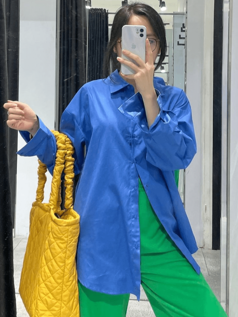 Look com bolsa amarela, camisa social azul e calça verde