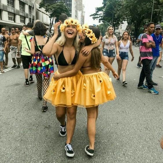 Duas amigas no bloquinho com fantasia de saia de tule amarelo