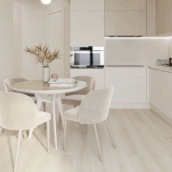 Cozinha minimalista com móveis brancos.
