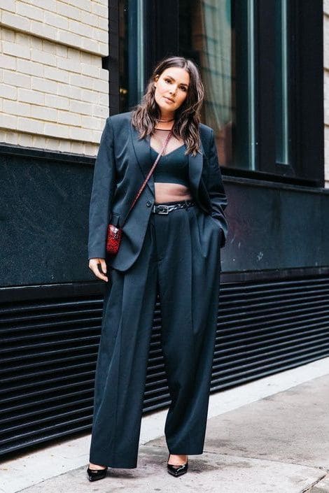 Mulher posando para foto usando look all black com cropped, calça e blazer de alfaiataria