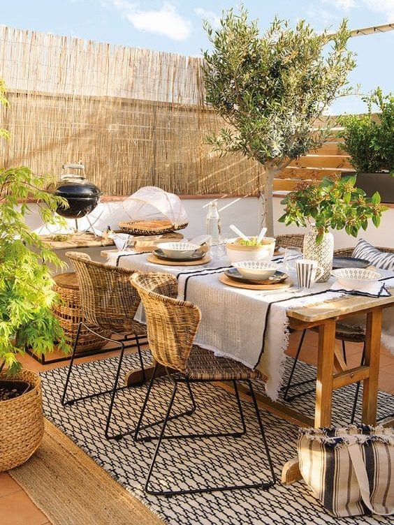 Quintal com mesa decorada em estilo boho