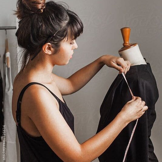 Mulher medindo a roupa representando o que a moda influencia na economia.