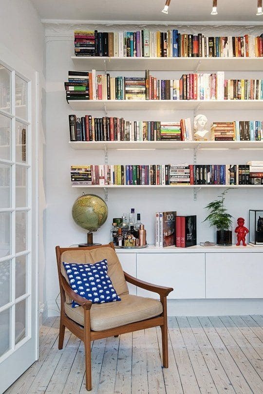 Livros em uma sala e uma poltrona