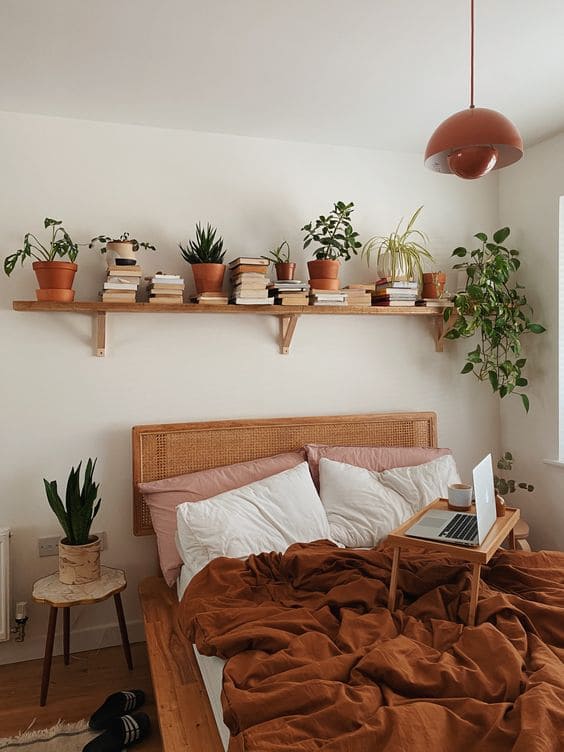 Livros acima da cama em uma prateleiras