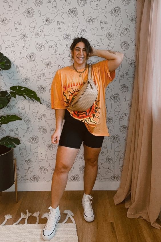 Mulher midsize com shorts de ginastica e camiseta laranja
