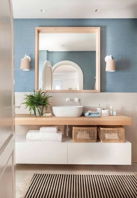 Banheiro com móveis de madeira e parede azul