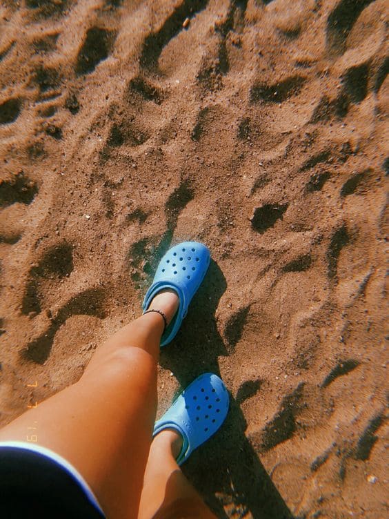 Crocs azul com areia de praia