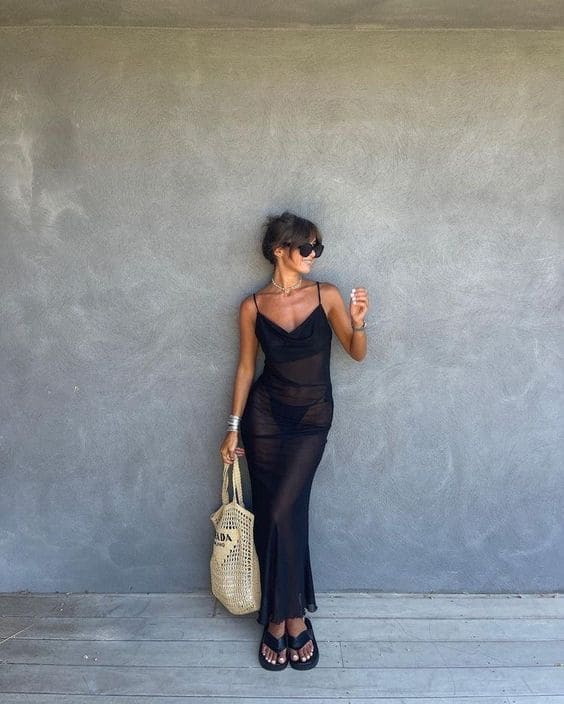 Mulher usando um look com vestido preto estilo praiano
