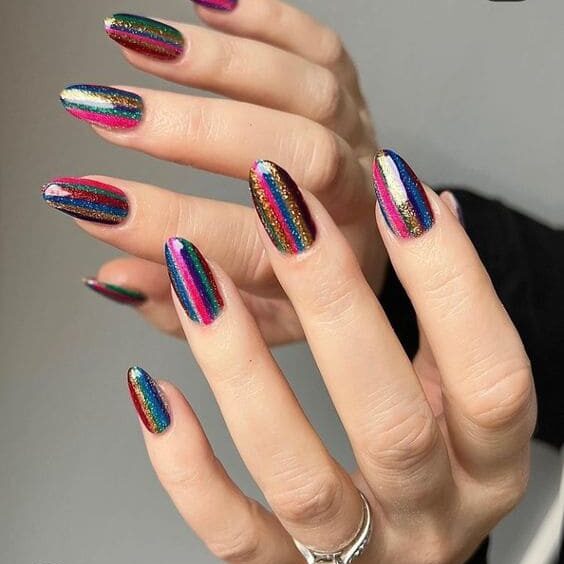 Mulher com as unhas pintadas nas cores do arco-íris