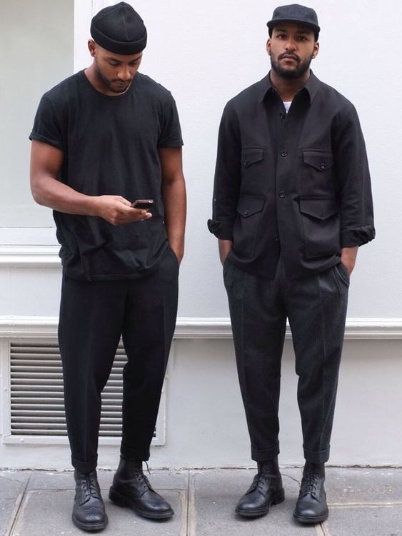 Foto de dois homens usando um look all-black e ambos estão usando um tipo de sapato masculino conhecido como derby