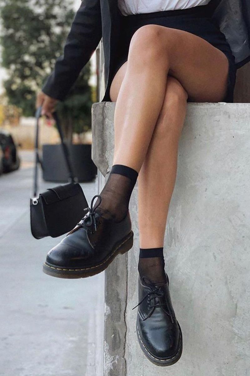 Pernas de uma mulher calçando sapatos de couro num exemplo de como cuidar de sapatos de couro